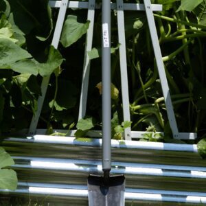 Garden trowel with metal structure and plants.