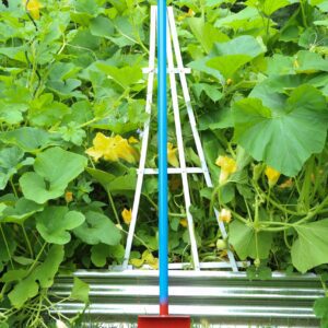 Colorful garden tool surrounded by green plants.