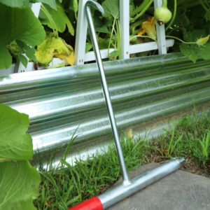 Garden tool with red handle on grass.