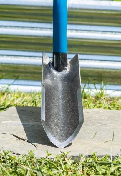 Blue-handled garden shovel blade on grass