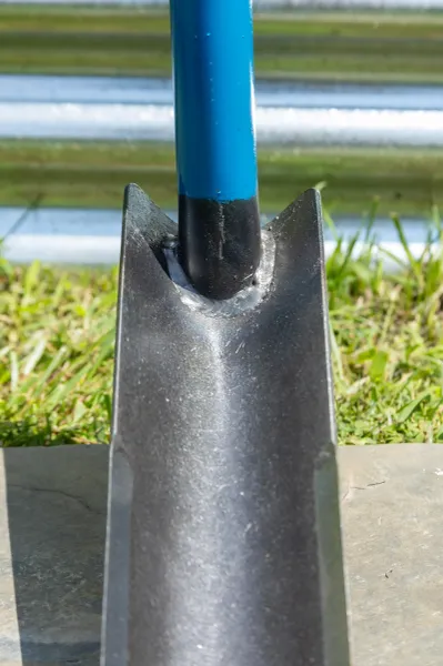 Close-up of blue-handled shovel blade