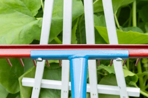 Blue and red garden rake on leaves