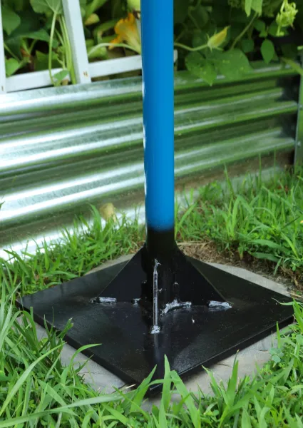 Blue pole on black metal base in grass