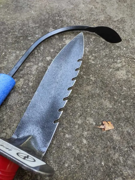 Close-up serrated knife blade on concrete